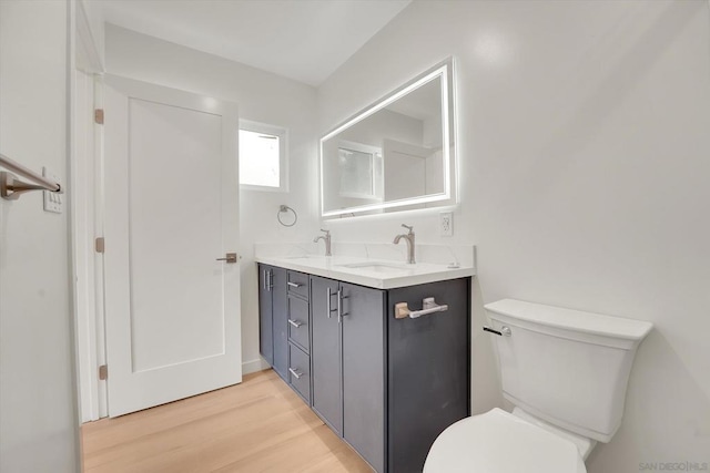 bathroom featuring vanity, hardwood / wood-style flooring, and toilet