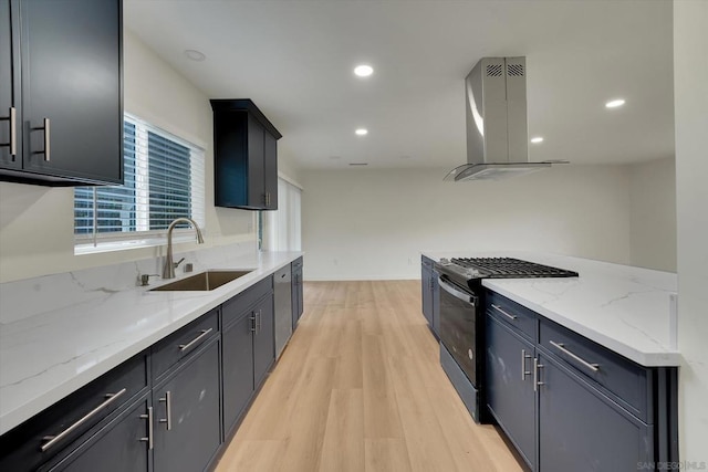 kitchen with sink, appliances with stainless steel finishes, light hardwood / wood-style floors, light stone countertops, and island exhaust hood