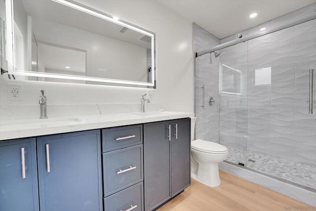 bathroom featuring walk in shower, wood-type flooring, toilet, and vanity