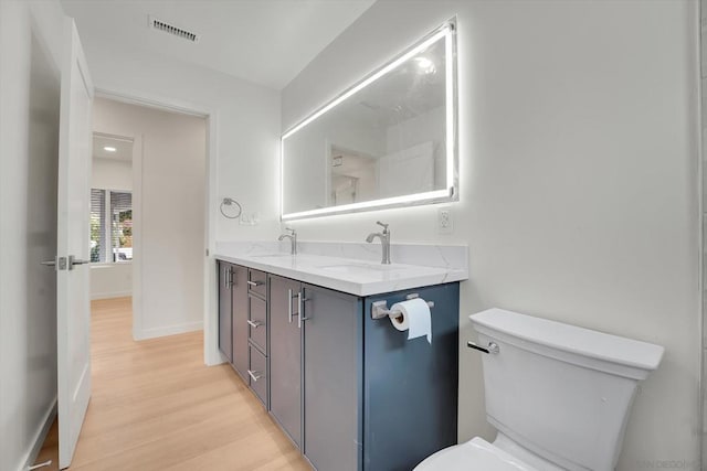 bathroom with vanity, hardwood / wood-style flooring, and toilet