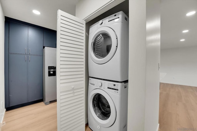 laundry room with stacked washer and clothes dryer and wood-type flooring