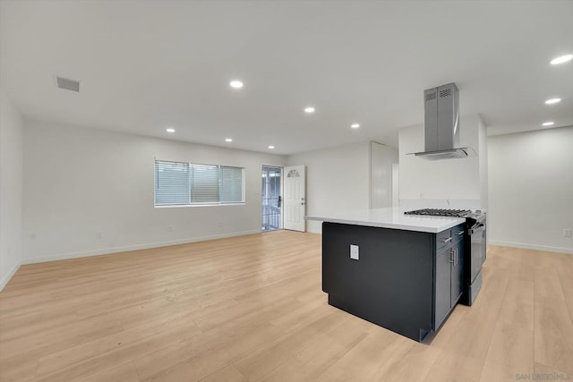 kitchen featuring extractor fan, light hardwood / wood-style floors, gas range oven, and a kitchen island