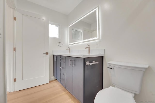 bathroom with hardwood / wood-style flooring, vanity, and toilet