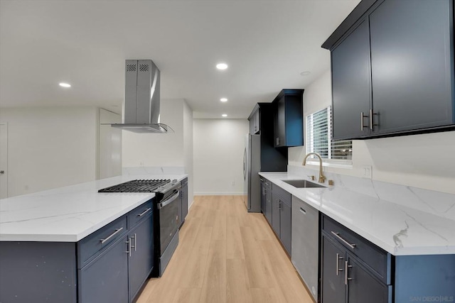 kitchen with sink, island range hood, light stone countertops, gas stove, and light wood-type flooring