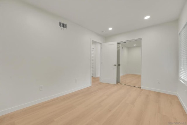 unfurnished bedroom with a closet and light hardwood / wood-style flooring