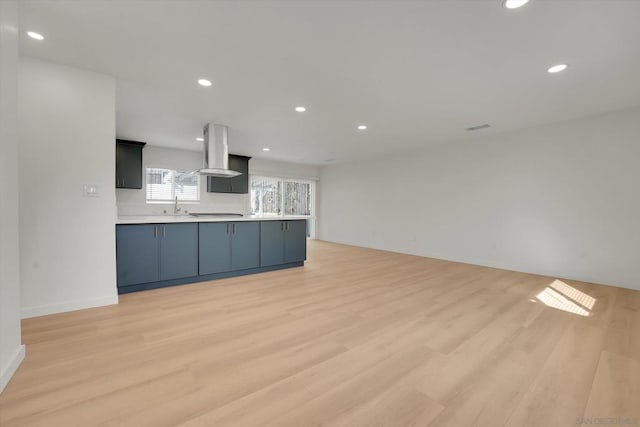 kitchen featuring sink, island range hood, and light hardwood / wood-style flooring