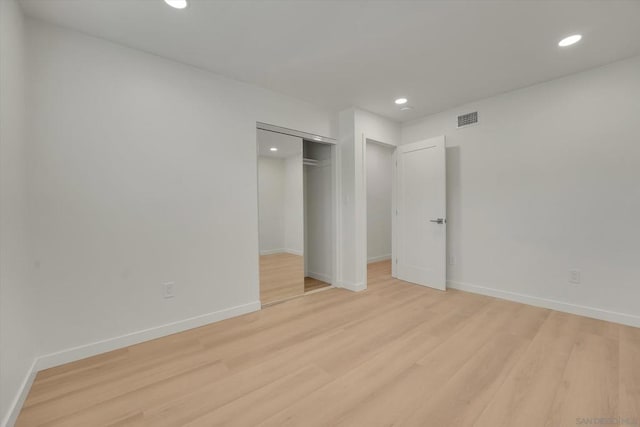 unfurnished bedroom with a closet and light wood-type flooring