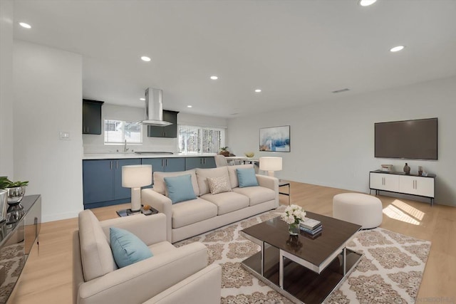 living room featuring sink and light hardwood / wood-style floors