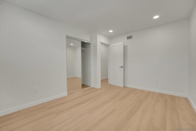 unfurnished bedroom featuring light hardwood / wood-style floors and a closet