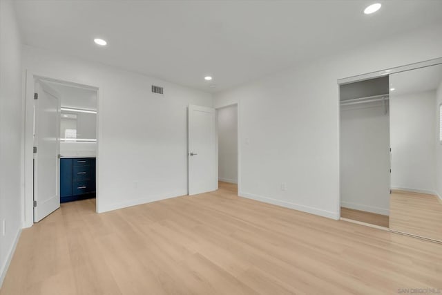 unfurnished bedroom featuring light hardwood / wood-style floors and a closet