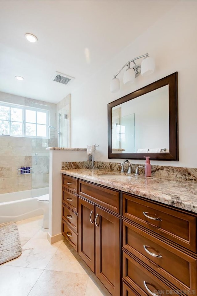 full bathroom featuring toilet, vanity, and shower / bath combination with glass door