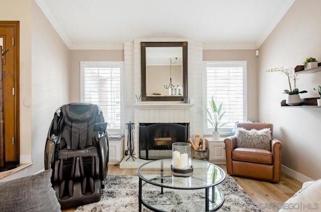 sitting room featuring a brick fireplace, a healthy amount of sunlight, and light hardwood / wood-style flooring