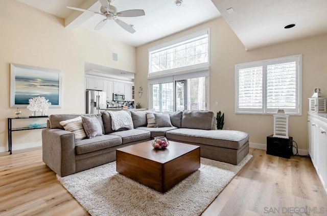 living room with beam ceiling, light hardwood / wood-style floors, and ceiling fan