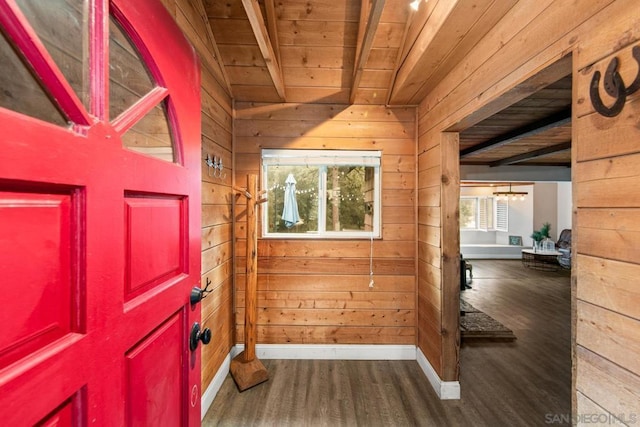 foyer with beamed ceiling, wood ceiling, dark hardwood / wood-style flooring, and wood walls