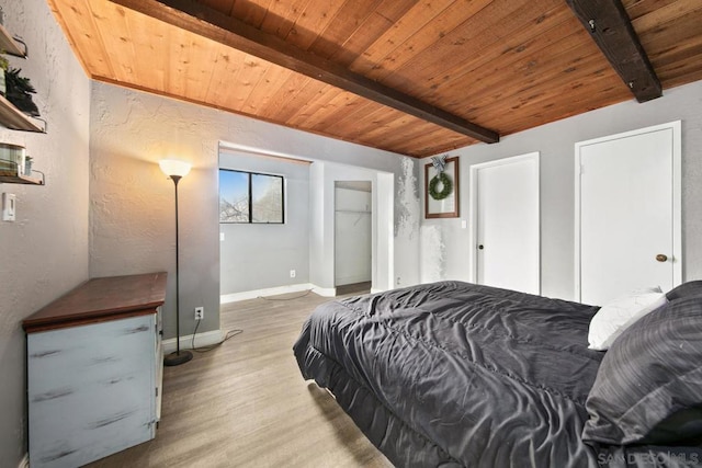 bedroom with beam ceiling, wood ceiling, and light hardwood / wood-style floors