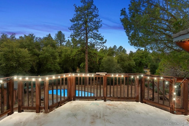 pool at dusk featuring a patio