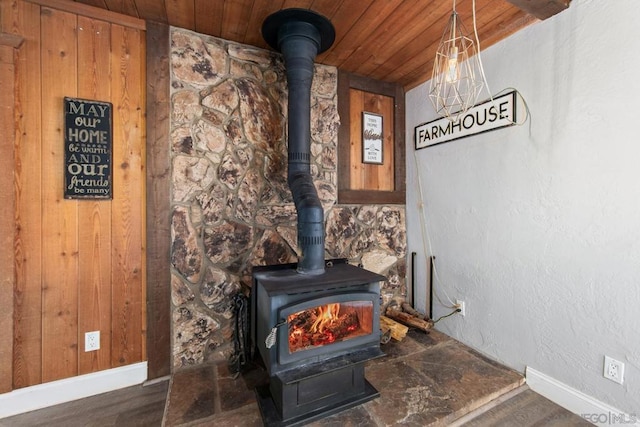 room details featuring a wood stove, wood ceiling, and wood walls