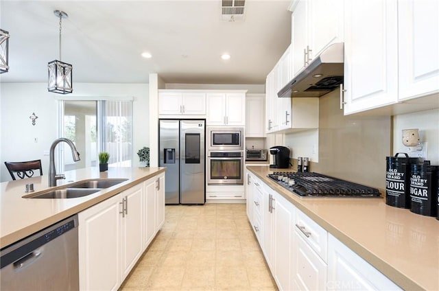 kitchen featuring white cabinetry, appliances with stainless steel finishes, sink, and pendant lighting