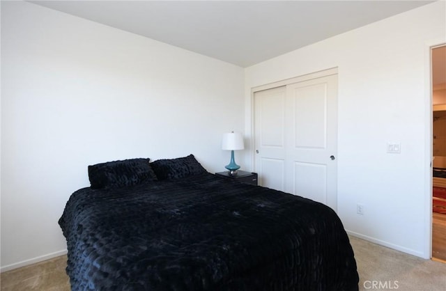 bedroom with light carpet and a closet