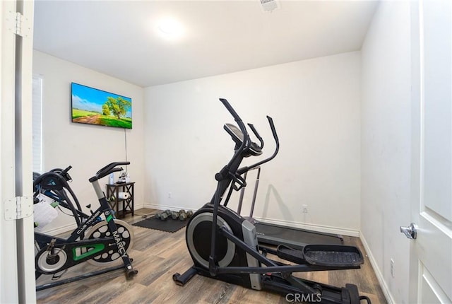 exercise room with wood-type flooring