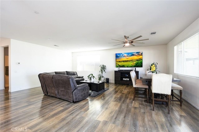 living room with dark hardwood / wood-style flooring and ceiling fan