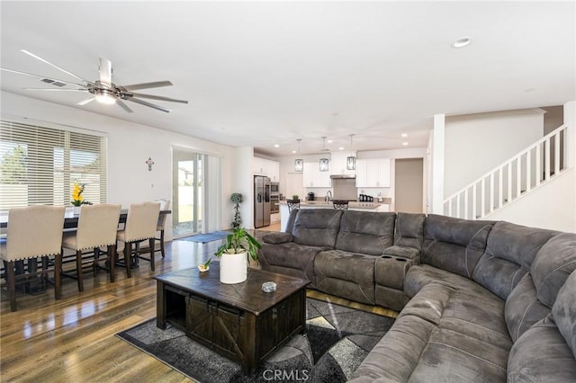 living room with dark hardwood / wood-style floors, sink, and ceiling fan