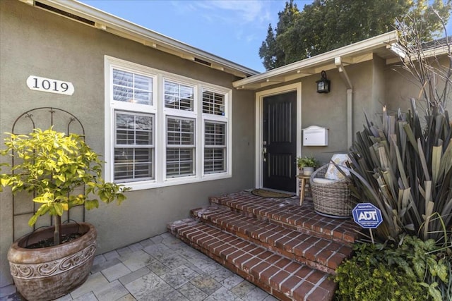 view of exterior entry with a patio area