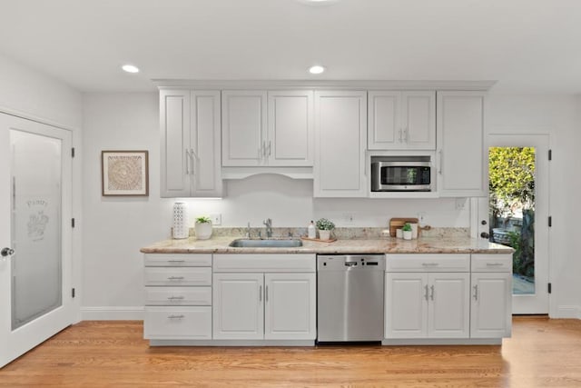 kitchen featuring white cabinetry, stainless steel appliances, sink, and light hardwood / wood-style flooring