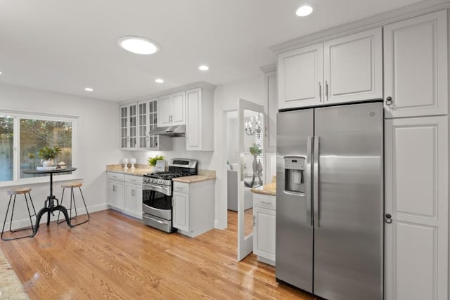 kitchen featuring light hardwood / wood-style flooring, light stone countertops, white cabinets, and appliances with stainless steel finishes