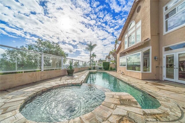 view of swimming pool with a patio, french doors, and an in ground hot tub