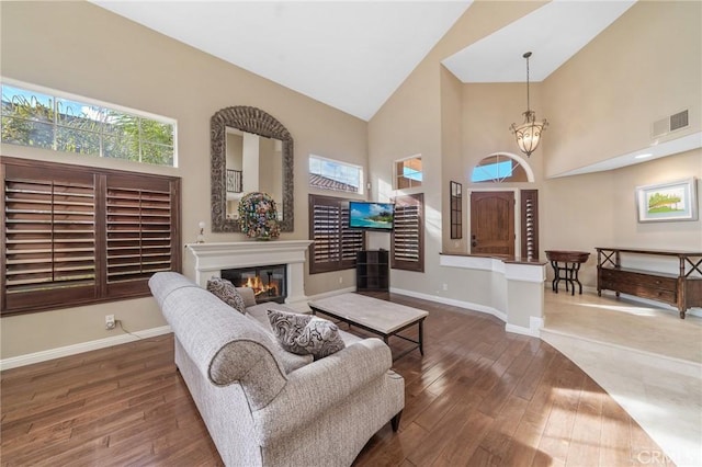 living room featuring a notable chandelier, high vaulted ceiling, and dark hardwood / wood-style floors