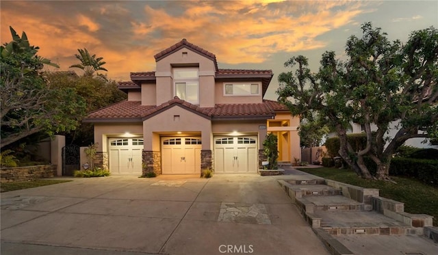 mediterranean / spanish-style house with a garage