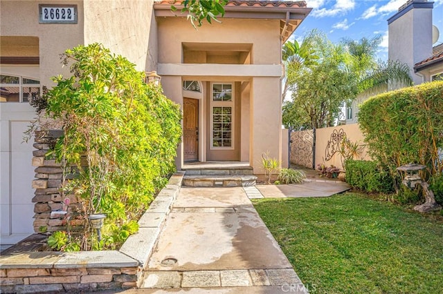 property entrance featuring a lawn