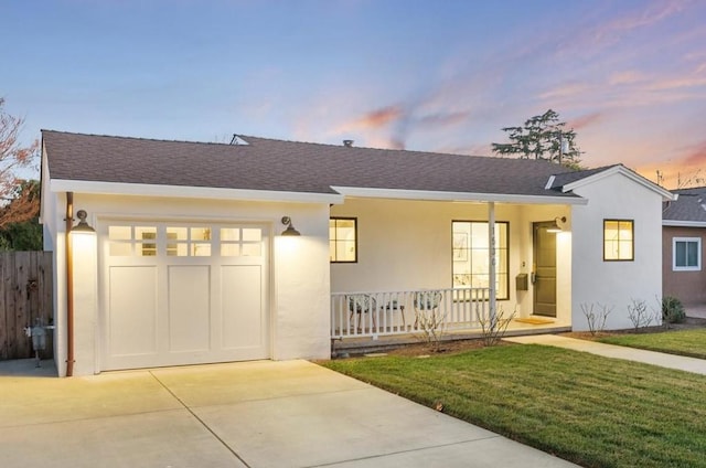 single story home with a garage, a yard, and covered porch