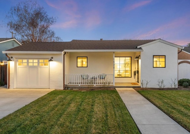 ranch-style house with a garage, a lawn, and covered porch