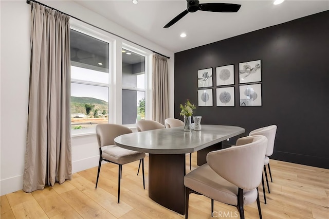 dining space with light hardwood / wood-style flooring and ceiling fan