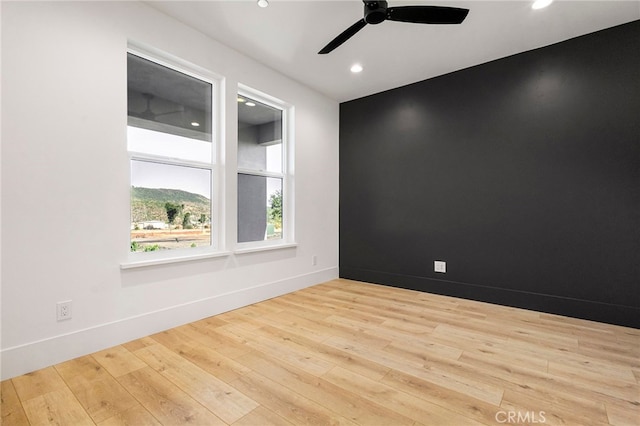 empty room with ceiling fan and light wood-type flooring