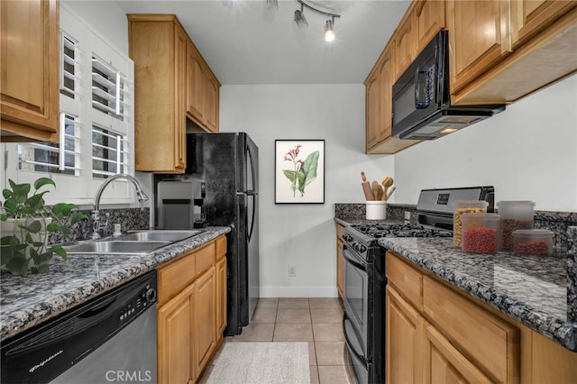 kitchen featuring sink, dark stone countertops, light tile patterned floors, and black appliances