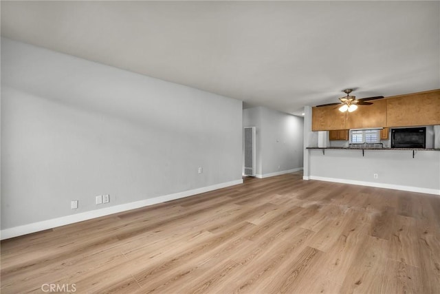 unfurnished living room featuring ceiling fan and light hardwood / wood-style floors