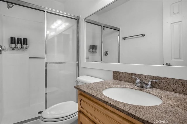 bathroom featuring toilet, vanity, and walk in shower