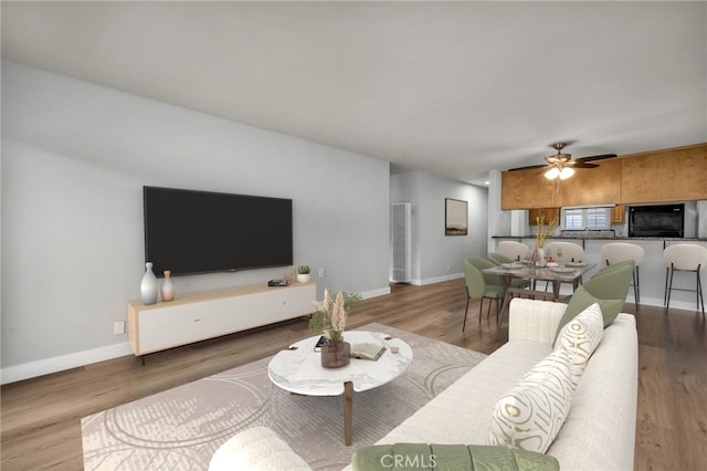 living room featuring hardwood / wood-style flooring and ceiling fan