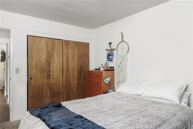 carpeted bedroom featuring a textured ceiling and a closet