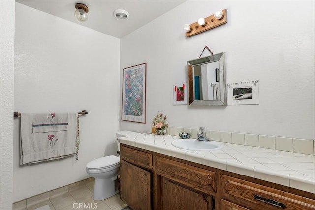 bathroom featuring vanity, tile patterned floors, and toilet