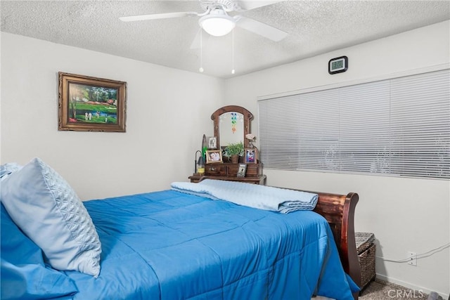 bedroom with a textured ceiling, carpet floors, and ceiling fan