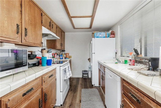 kitchen featuring dark hardwood / wood-style floors, sink, tile countertops, and white appliances