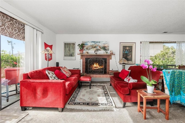 living room featuring carpet flooring, a tile fireplace, and a textured ceiling