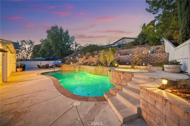 pool at dusk with a patio area