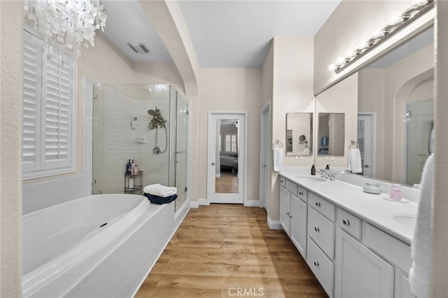 bathroom with wood-type flooring, independent shower and bath, and vanity