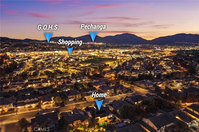 aerial view at dusk featuring a mountain view