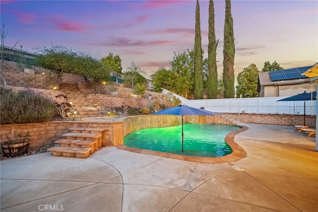 pool at dusk featuring a patio